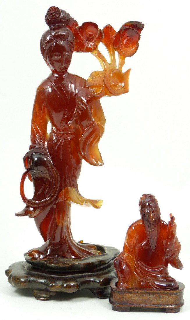 Pr CHINESE CARVED CARNELIAN STONE FIGURES: Pair of Chinese hand caved carnelian figures. One depicting Quan yin with flowers and the next depicting a seated wise man. Each having fitted wooden bases. Largest measures 6 3/4" height + 1" base he