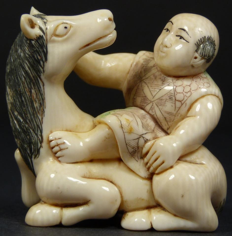 JAPANESE CARVED IVORY POLYCHROMED NETSUKE FIGURE: Hand carved polychromed netsuke figure depicting a man sitting on a horse. Singed to bottom. Fine quality. Measures 1 7/8" height x 1 3/4" width (4.7cm x 4.5cm).