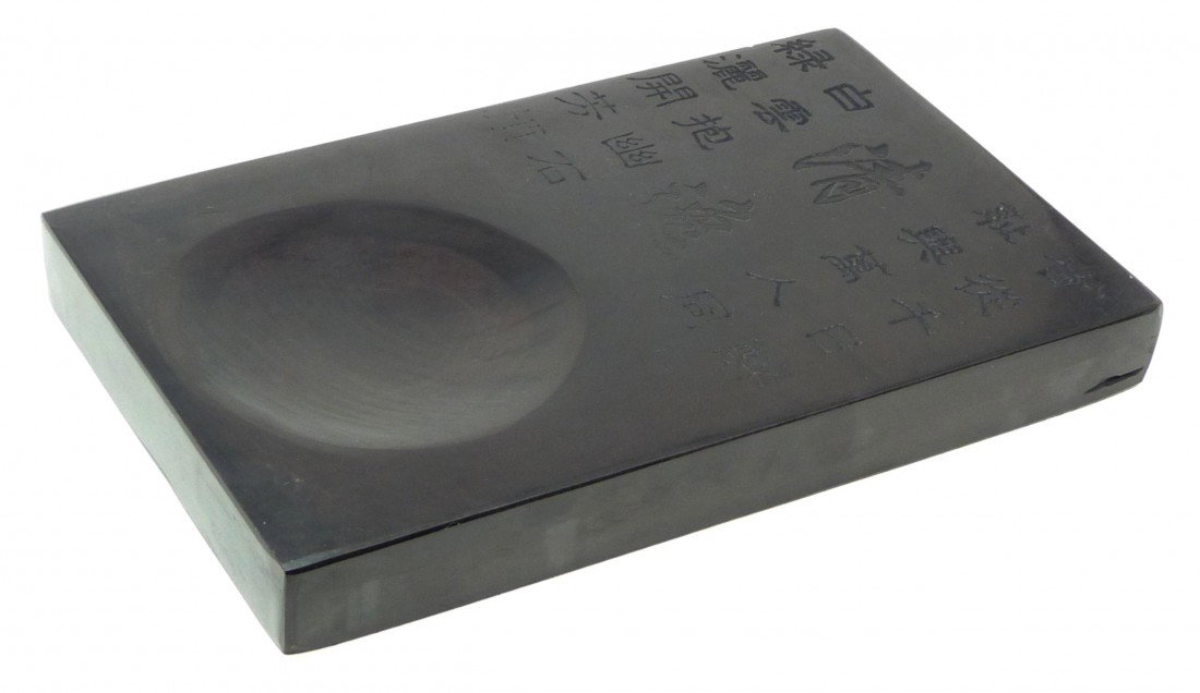 CHINESE CARVED INKSTONE IN ZITAN WOODEN BOX: Chinese hand carved inkstone slab in Zitan wooden box. Has etched calligraphy design to ink slab and box citing poetry from famous Chinese poet Huang Tingjiang (1045-1105). Slab measures 9" length x 5