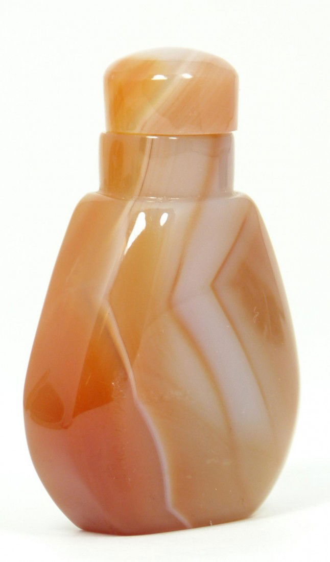 19TH/20TH CENTURY CHINESE RED AGATE SNUFF BOTTLE: A red banded agate snuff bottle with matching top. Bottle shaped form. 2 1/4 “ x 1 3/8” ( 5.43cm x 3.48cm)