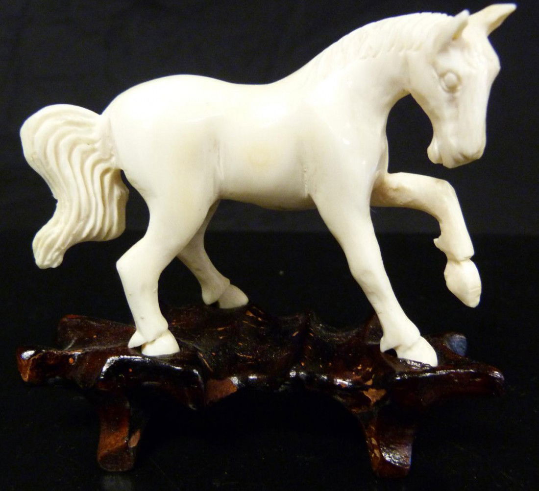 CHINESE IVORY HAND CARVED HORSE FIGURE: Chinese hand carved ivory figure of a standing horse with left hoof up. Has fitted wooden base. Measures 2 1/8" height x 2 7/8" length (5.4cm x 7.3cm). Ivory weight of 47 grams.