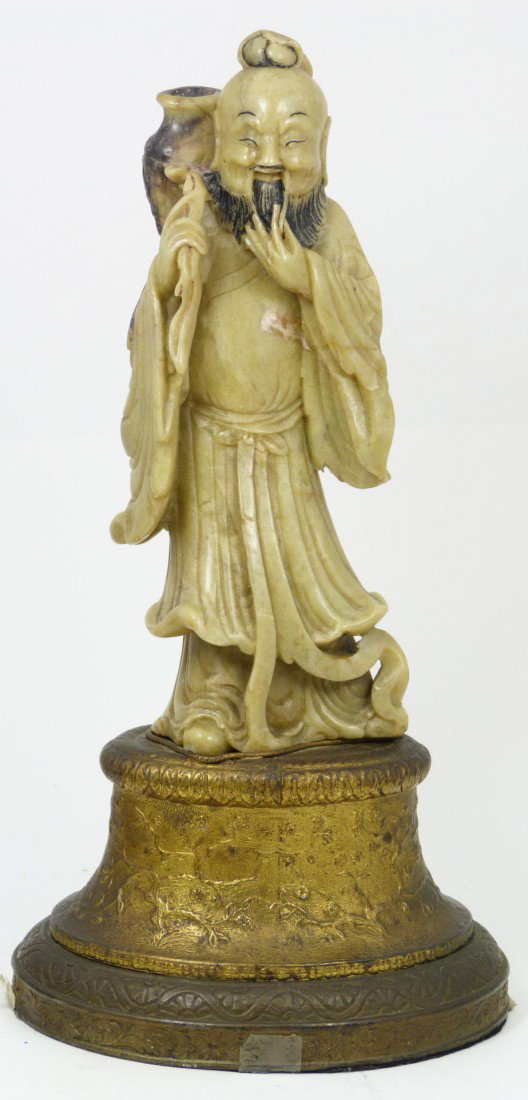 CHINESE HAND CARVED SOAPSTONE IMMORTAL FIGURE: Antique Chinese hand carved soapstone figure depicting an immortal with vase over shoulder and wearing layered robe. Mounted to lamp base. 19th century. Measures 8 5/8" height + 3 1/2" height (21.9cm 
