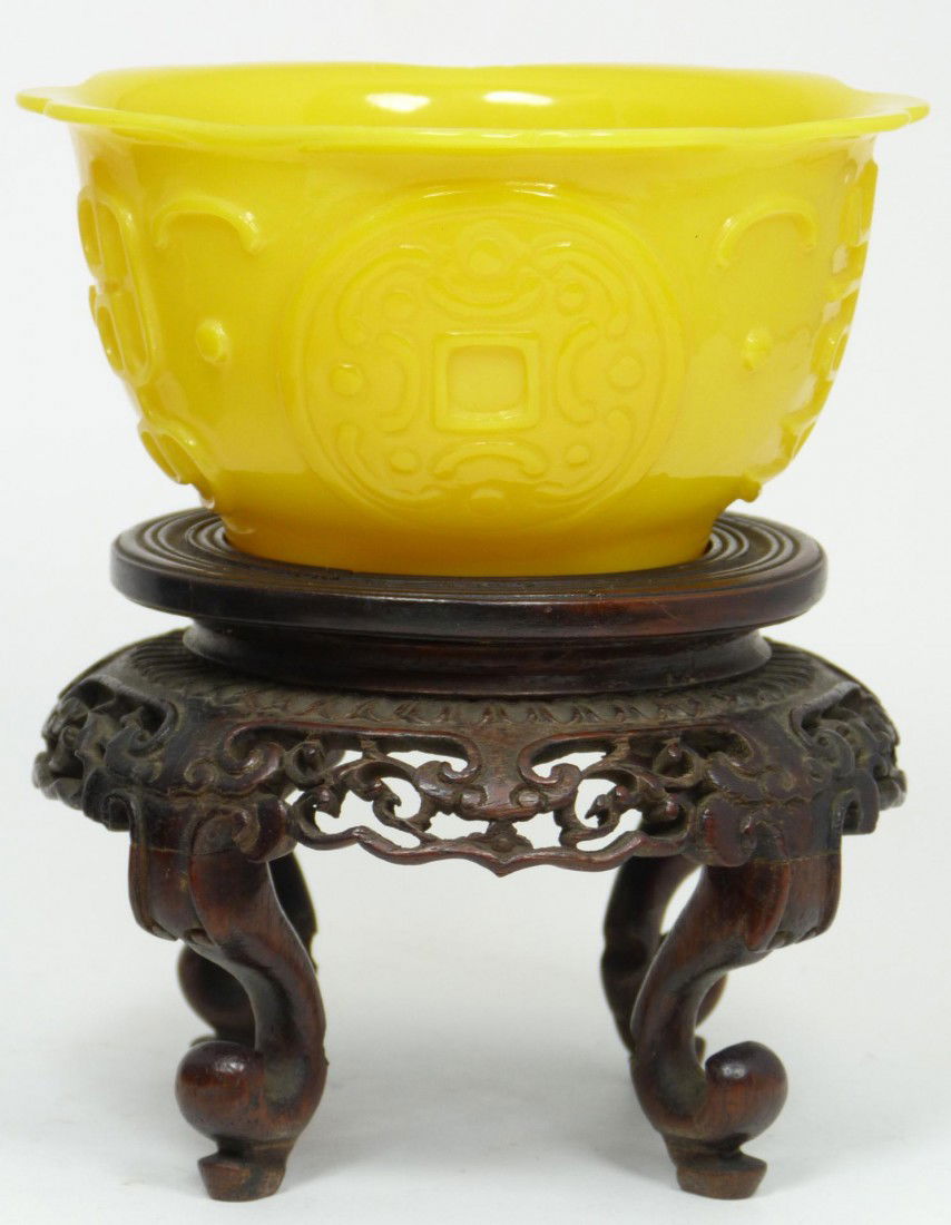 CHINESE CHING IMPERIAL PEKING GLASS YELLOW BOWL: Chinese Ch'ing Dynasty period Imperial Peking Glass egg yolk yellow bowl having flora form scalloped rim and raised calligraphy and coin design to exterior. Finely crafted. Includes fitted wooden disp