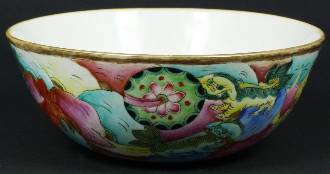 CHINESE QING DYNASTY PORCELAIN FOO DOGS BOWL: Antique Chinese hand painted enameled porcelain bowl. Depicts 7 foo dogs playing with balls in a vivid multicolor design. Interior depicts peach to center. Gilt rim. Bottom holds Qing Dynasty stamp ar