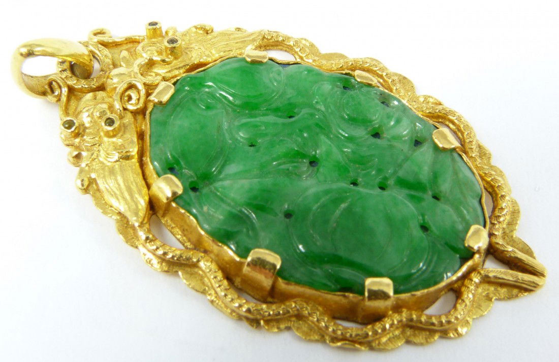 24K YG CHINESE JADEITE DRAGONS PENDANT: Chinese jadeite pendant fully relief carved depicting peaches and gourd and mounted in 24k yellow gold with double dragons design. Hold calligraphy Bao He Zu Jing marks to verso. Measures 1 5/8" heigh