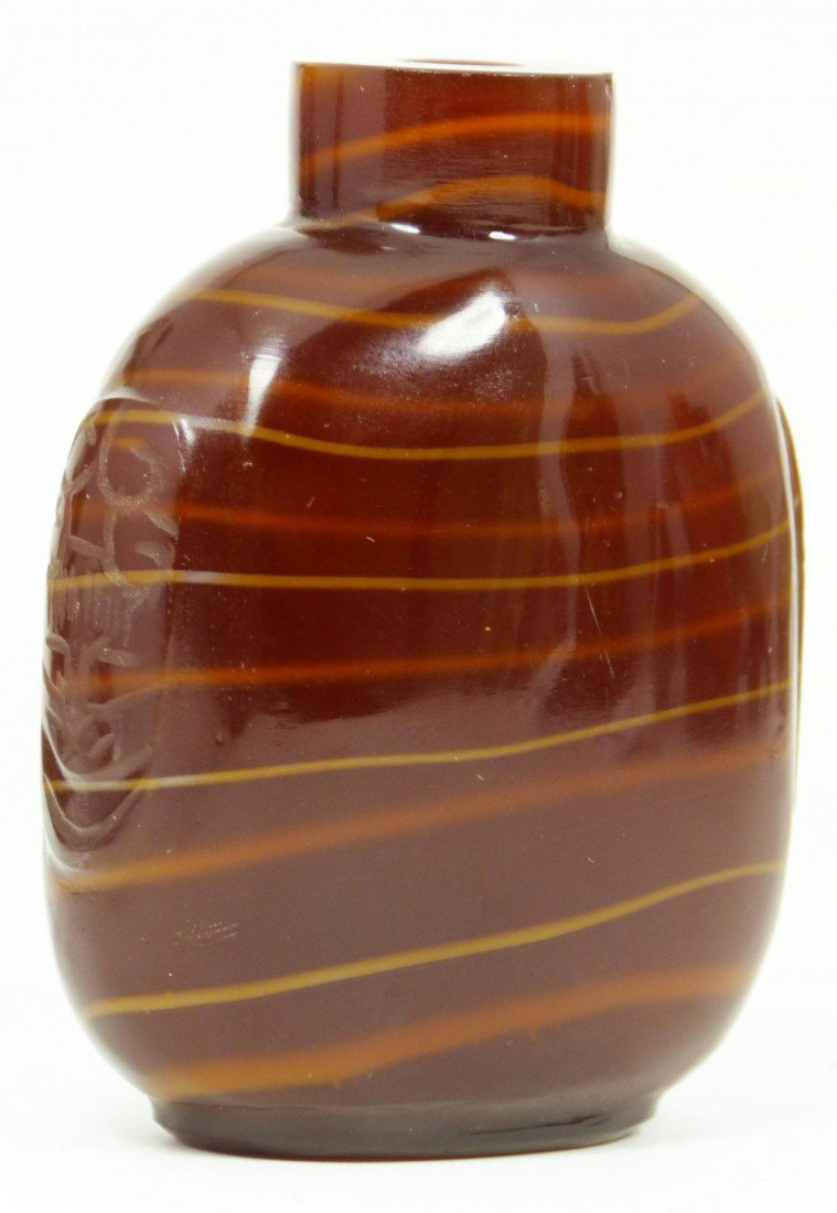 19TH/20TH CENTURY CHINESE RED AGATE SNUFF BOTTLE: Chinese glass snuff bottle imitating red lined agate. Has etched raised design to sides. 19th/20th century. Measure 3“ height x 2 3/8” ( 7.6cm x 6.1cm). Total weight 126 grams.