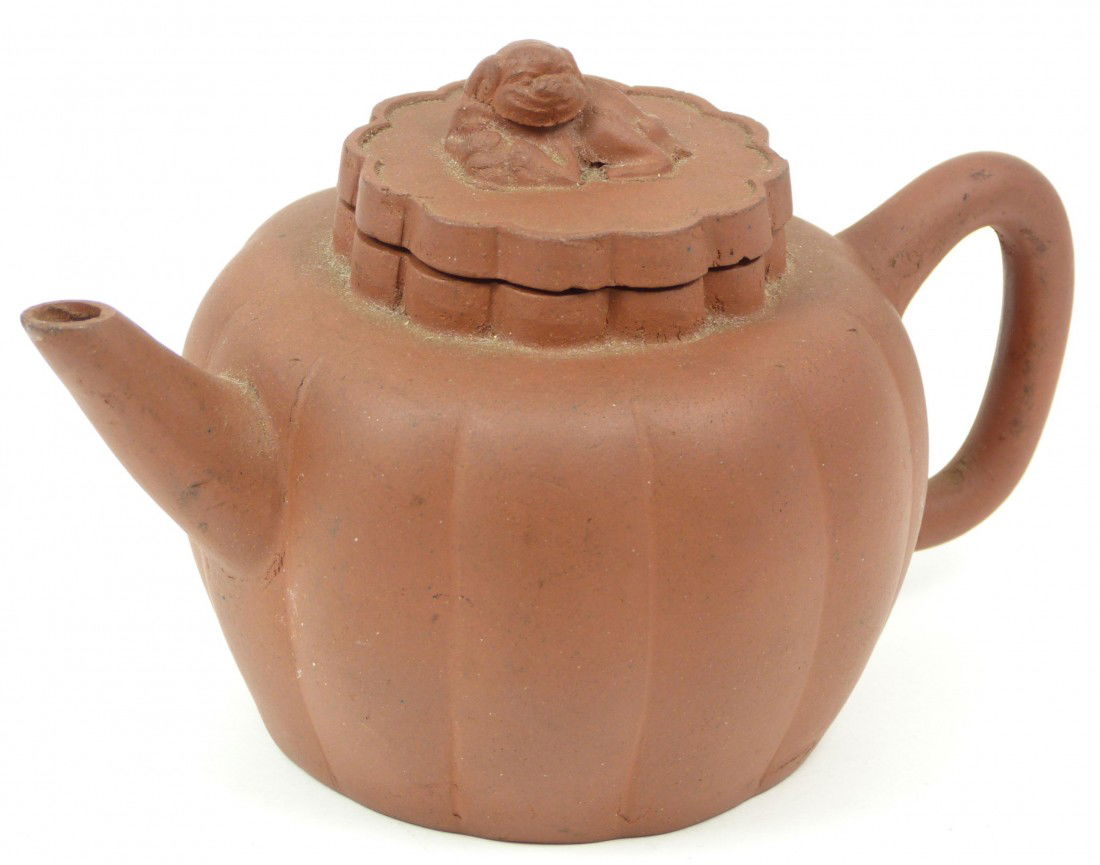 CHINESE YIXING ZISHA EARTHENWARE TEA POT: Chinese Yixing Zisha earthernware teapot with ribbed pumpkin shaped body and foo dog cover. Holds impressed Yi Xing Zi Sha calligraphy mark to bottom. Measures 7 1/4" length x 4 3/8" height (18.4cm x