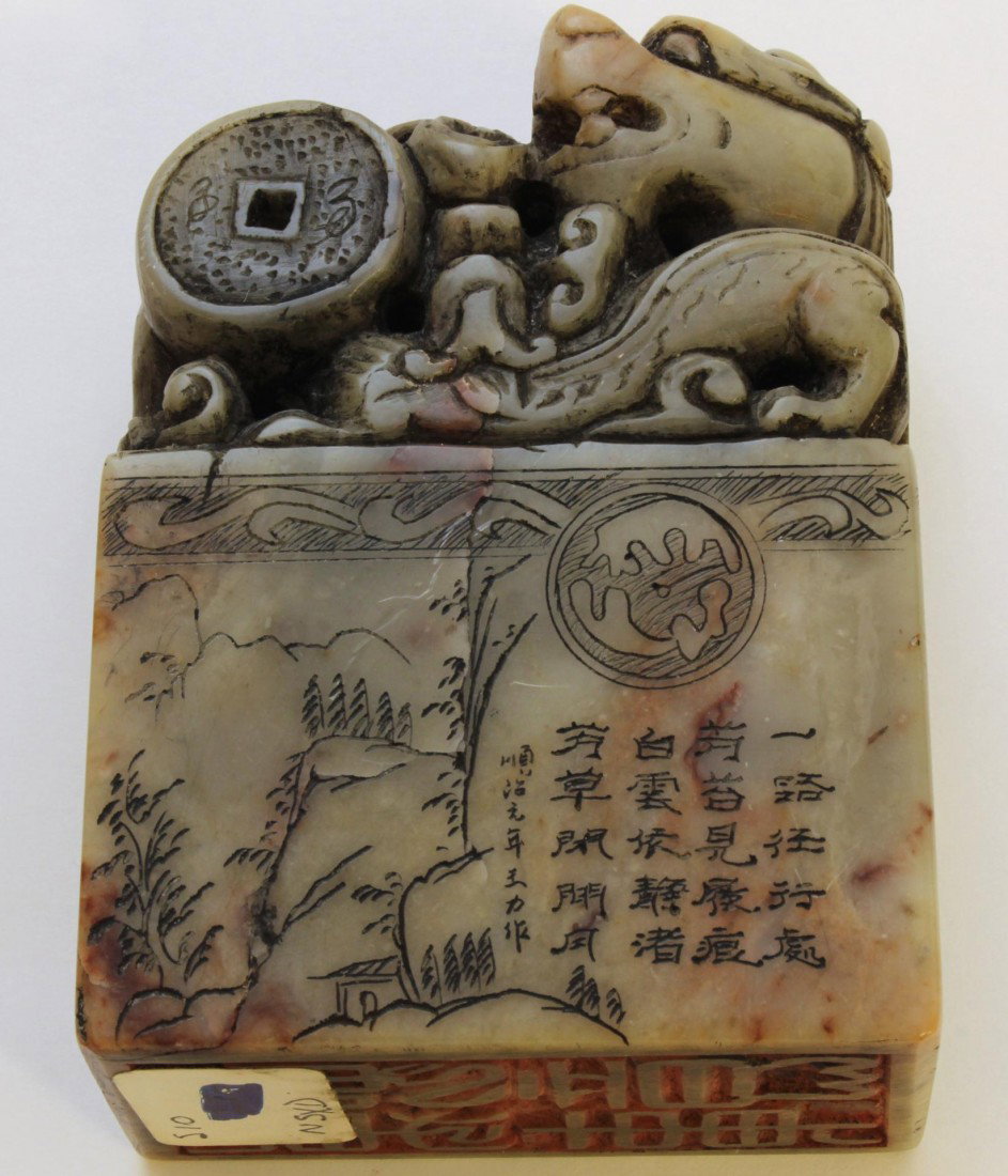 19th C CHINESE CARVED SOAPSTONE CHOP SEAL: Antique Chinese hand carved soapstone chop seal depicting a foo dog with child and coin. Etched calligraphy throughout slab with landscape scenes. 19th century. Measures 3 5/8" height x 2 1/2" width x