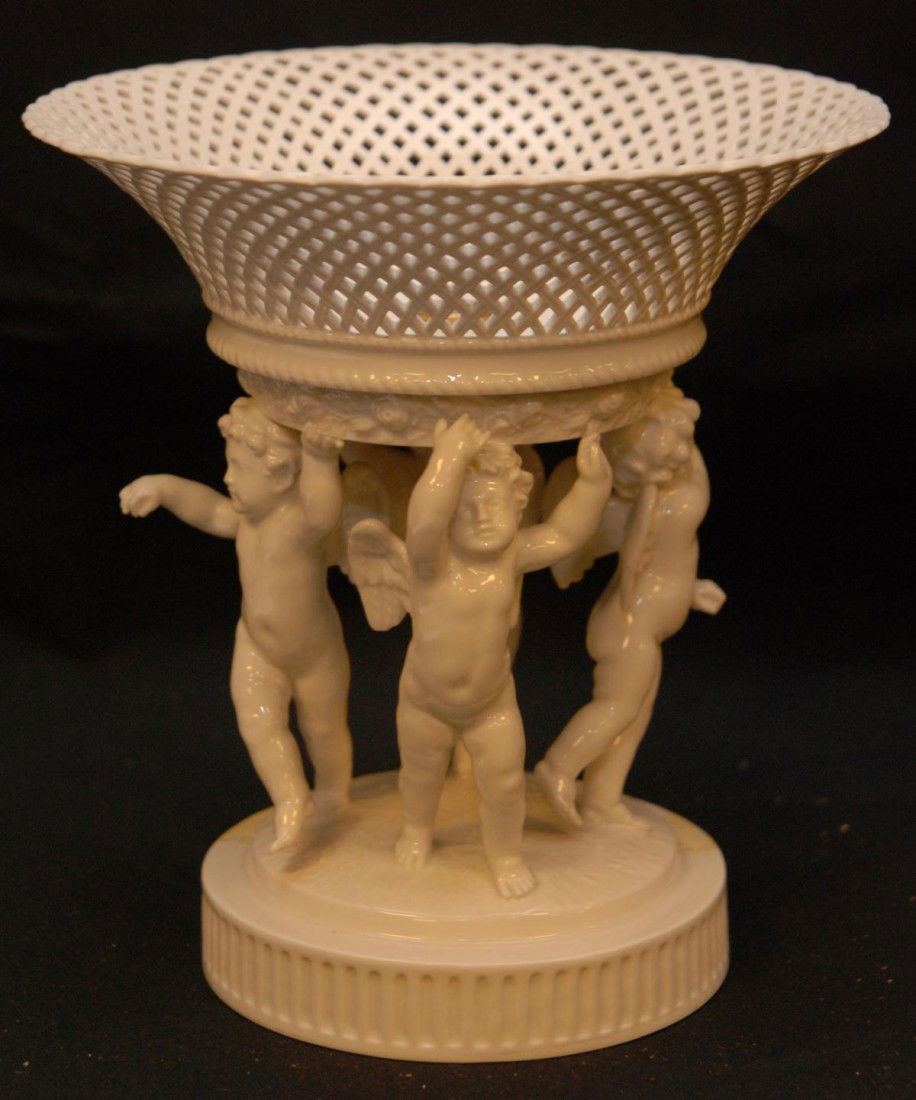 KPM GERMAN WHITE PORCELAIN CHERUBS COMPOTE: Antique Berlin KPM white porcelain figural cherubs compote. Depicts 4 winged cherubs holding up a mesh basket and having ribbed base. Holds blue KPM scepter mark to bottom. 19th century. Measures appr