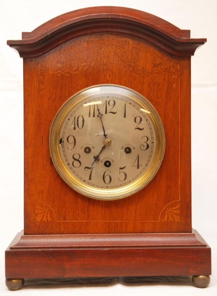 JUNGHANS GERMAN WALNUT MANTLE CLOCK: 19th century Junghans German mantle clock with walnut case. Has silver face with black enamel Arabic numerals. Black hour and minute hands Knight's cross and Iron Cross design. Movement marked B06. Me