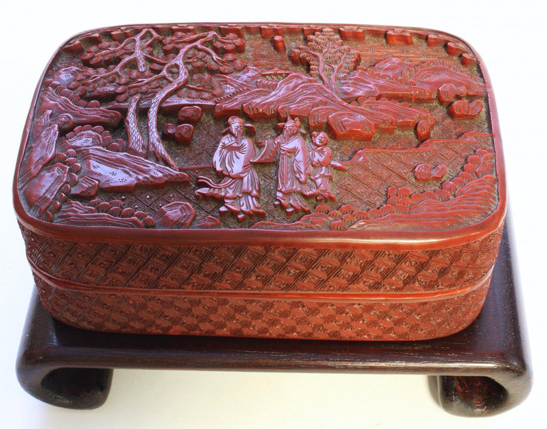 CHINESE MING DYNASTY CARVED CINNABAR BOX: Antique Chinese lacquer cinnabar box having relief carved design throughout depicting sages in a landscape setting with trees and mountains and attendant. Black lacquer interior and bottom. Box has te