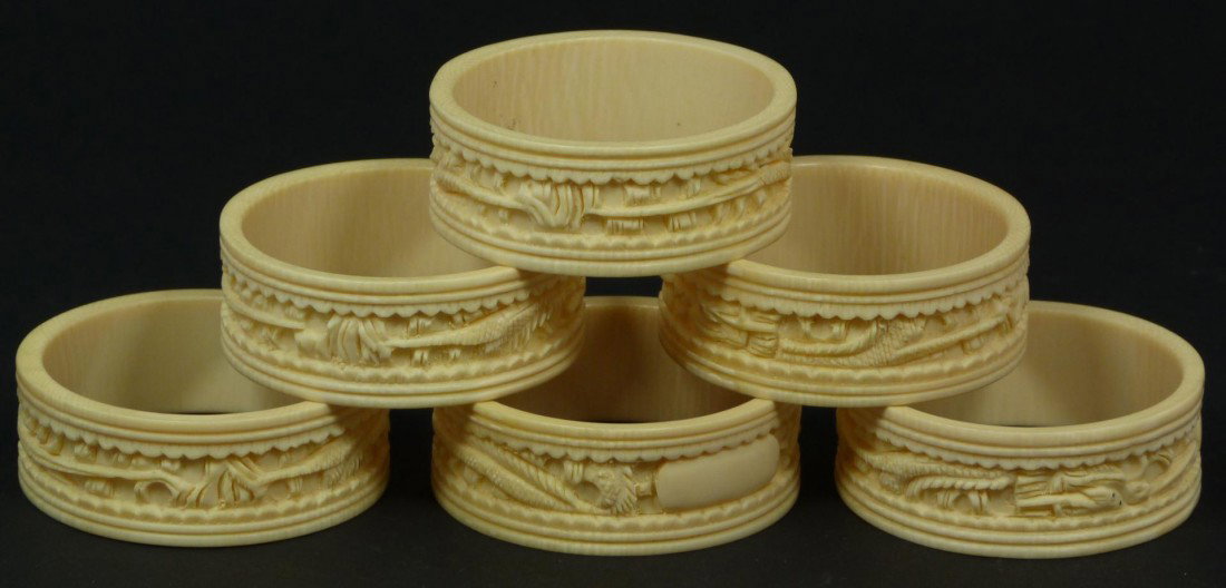 6 CHINESE CARVED IVORY ELEPHANT NAPKIN RINGS: 6 Chinese relief carved ivory napkin rings depicting flying dragons. Each approximately 2" diameter x 3/4" depth (5.1cm x 1.9cm). Total ivory weight of 80 grams.