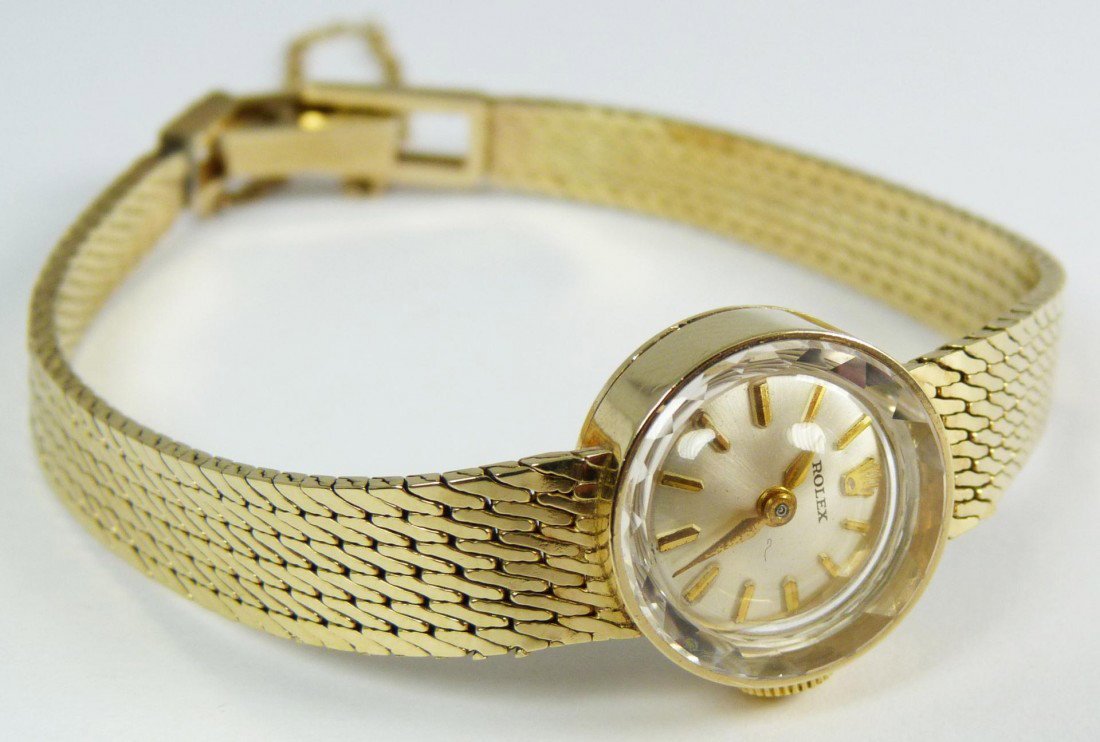 LADIES ROLEX 14K YELLOW GOLD WATCH: Ladies Rolex 14k yellow gold watch having silvered face with gold notches. Gold hour and minute hands. Measure approx. 4 3/8" length (11.1cm) including the band. Case measures 5/8" diameter (1.6cm). T