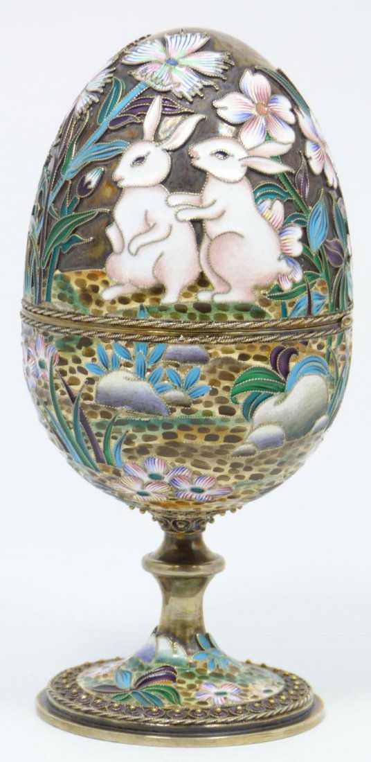 IMPERIAL RUSSIAN SILVER ENAMELED EGG OVCHINNIIKOV: Russian silver enameled hinged egg box depicting rabbits with flowers. Gold wash interior. Piece holds Cyrillic Pavel Akimov Ovchinnikov workmaster marks. Holds 84 silver purity mark with town mark an