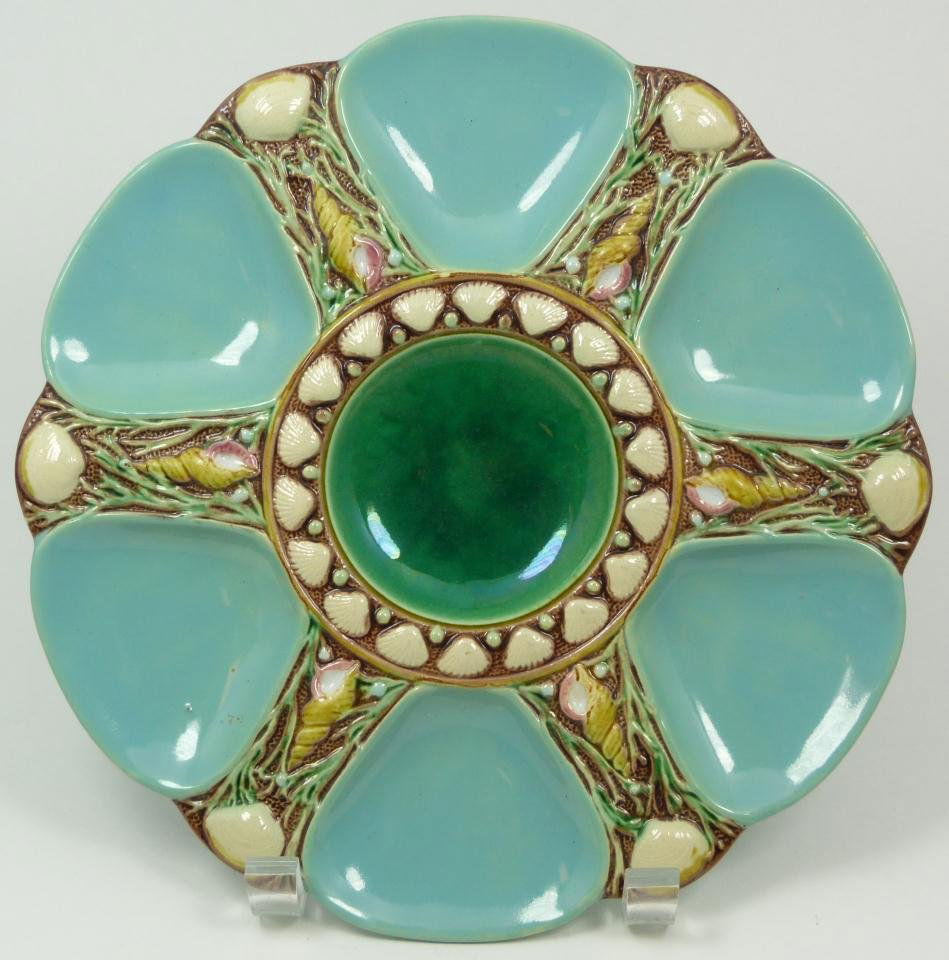 ANTIQUE MINTON MAJOLICA OYSTER PLATE: Antique Minton English Majolica earthenware oyster plate. Has raised shell and seaweed design throughout. Made to serve 6 oysters. Holds impressed Minton mark to bottom with raised registration mark.