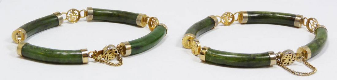PAIR OF CHINESE CARVED JADE CHARM BRACELETS: Pair Chinese hand carved jade charm bracelets. Each has a jade cylinder design linked by gold calligraphy design links. Each measures approximately 7 1/2" length (19cm)