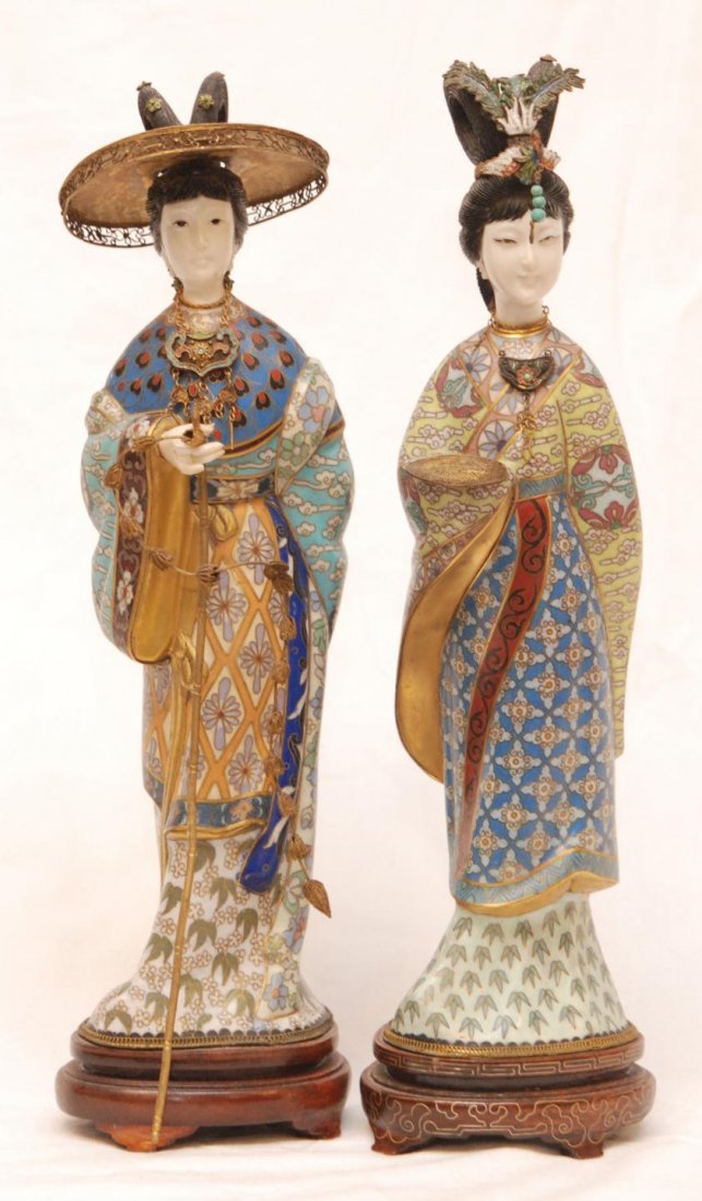 Pr CHINESE CLOISONNE & IVORY MAIDEN FIGURES: Pair of old Chinese enameled brass and ivory maiden figures. One has Phoenix head dress and the other having hat. Each depicted wearing layered robe with intricate patterns throughout. One is holding 