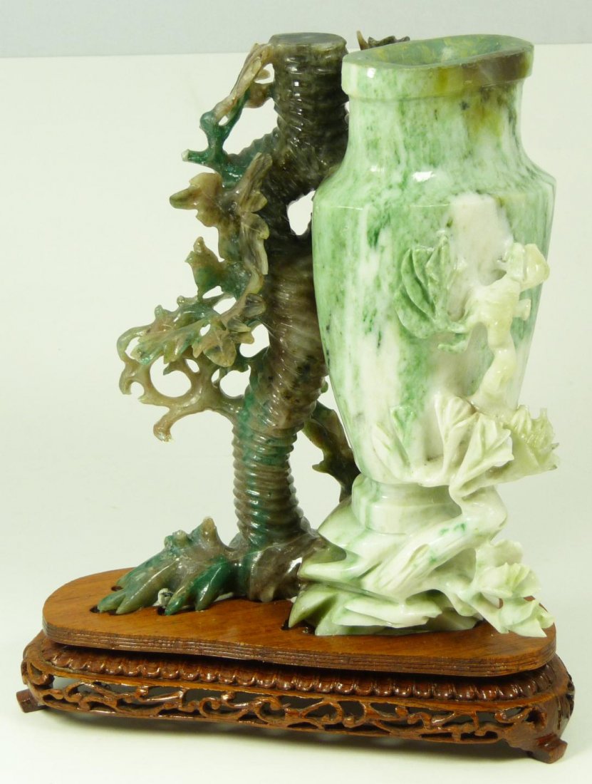 CHINESE HAND CARVED JADE FIGURAL VASE URN: Old Chinese hand carved jade urn having a figural vase design with tree and bird. Includes fitted wooden base. Measures 8" height x 6 1/2" width + 1 1/2" base height (20.3cm x 16.5cm + 3.8cm). Total w