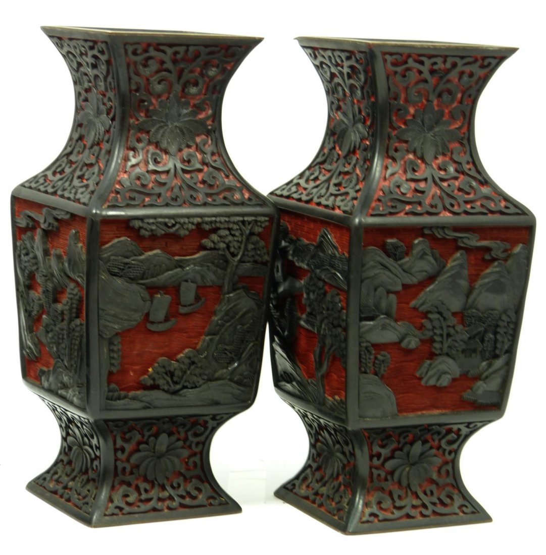PAIR OF CHINESE CARVED CINNABAR GU VASES: Pair of Chinese relief carved gu form cinnabar vases having a two tone black and red design depicting coastal scenes. Has gilt rim. Measures 9" height x 4" width x 4" depth (22.8cm x 10.1cm x 10.1cm).