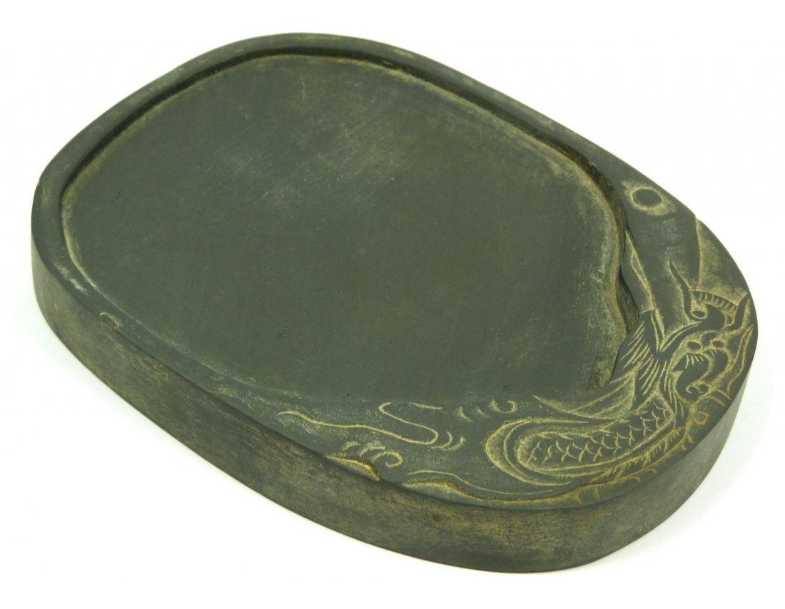 CHINESE HAND CARVED DUAN DRAGON SCHOLARS INKSTONE: Antique Chinese hand carved duan stone scholar's desk inkwell having relief carved design depicting a dragon with pearl. 19th century. Measures 5 1/8" length (13cm). Total weight of 440 grams.