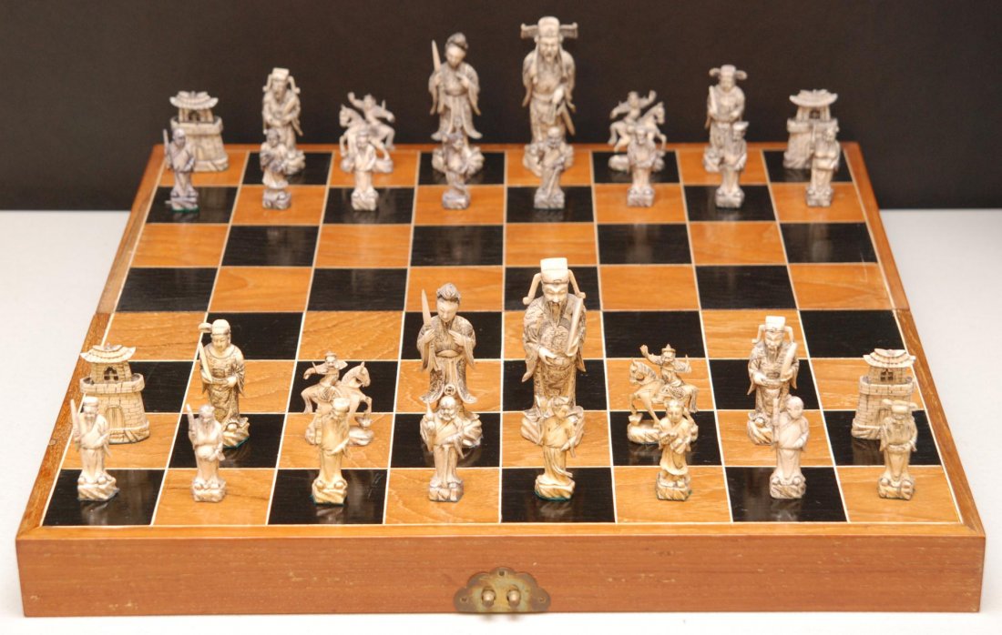 CHINESE IVORY CARVED IVORY CHESS SET w BOX BOARD: Old Chinese hand carved chess set with pieces constructed of ivory. Includes fitted wooden box that is also game board. Largest piece measures 4 5/8" height (11.7cm). Smallest piece measures 2 3/8" he