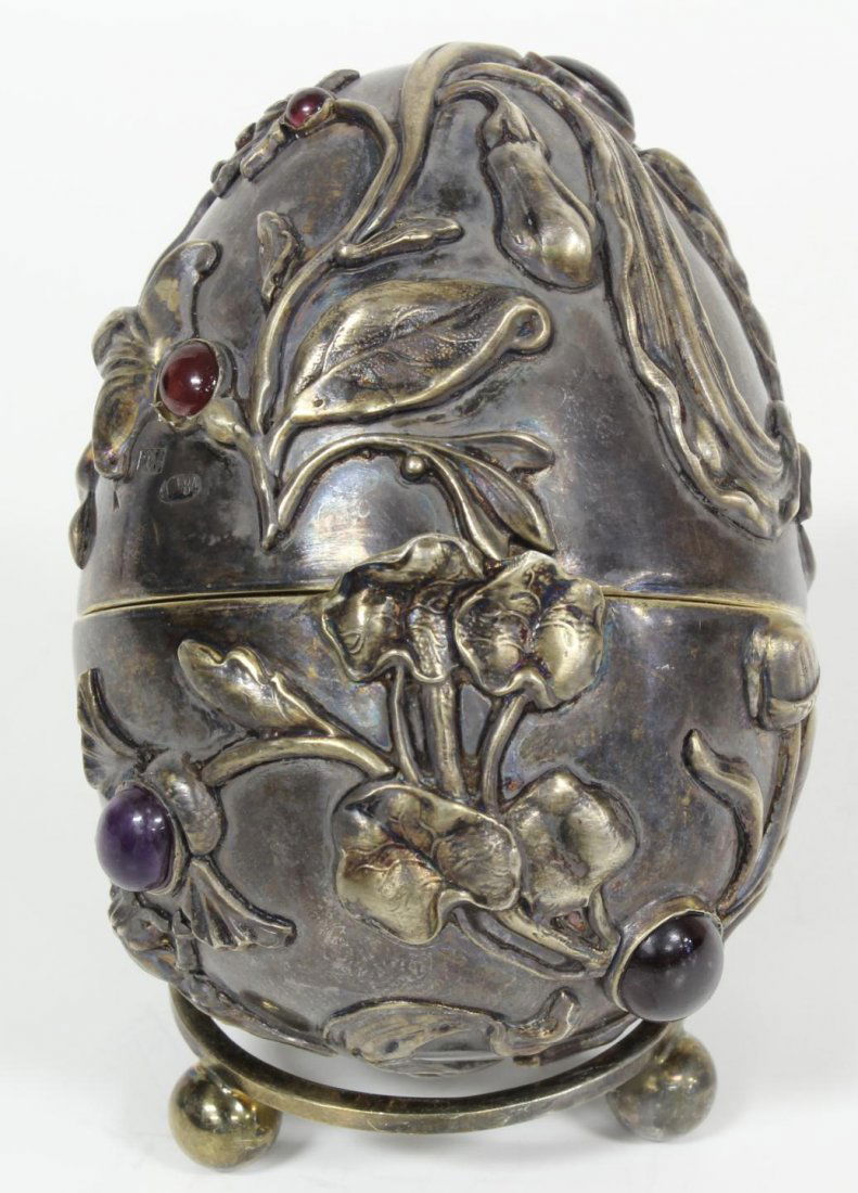 RUSSIAN SILVER JEWELED INSECTS EGG: Incredible Russian silver egg. Has intricate raised design depicting bees with flowers. Mounted with Cabochon garnets throughout. Gold wash interior. Has Ivan Petrovich Khlebnikov workmaster marks to