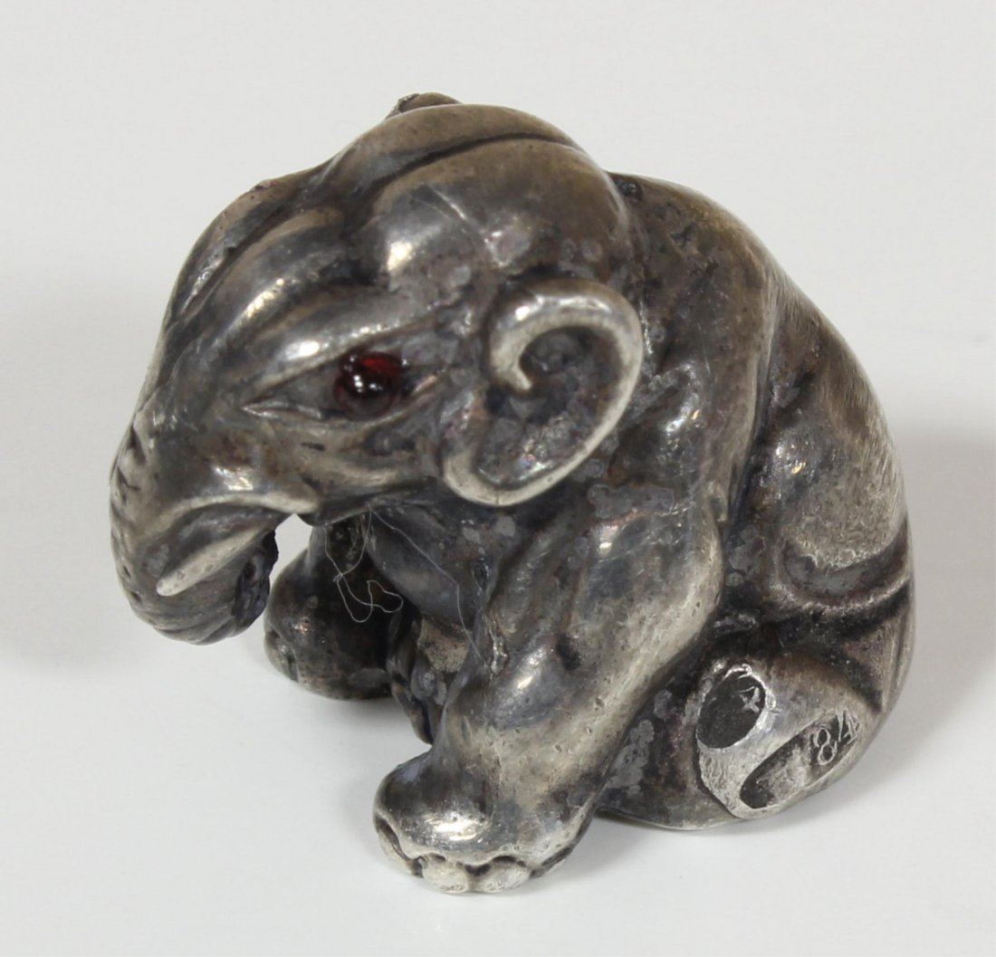 RUSSIAN SILVER SEATED ELEPHANT FIGURE: Russian silver seated elephant figure having cabochon cut ruby jewels set to eyes. Holds town marks and 84 silver purity marks to side. Holds Julius Rappoport workmaster marks to side. Measures 5/8" h