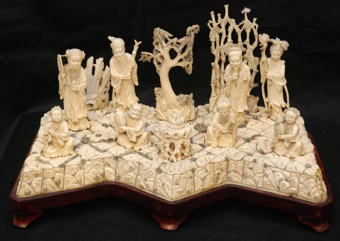 CHINESE HAND CARVED 8 IMMORTALS GROUP SCENE: Large Chinese hand carved ivory landscape group scene depicting the 8 Immortals on terra form base with trees and rock formations. In the center foreground is a table with peaches. 19th century. Inclu