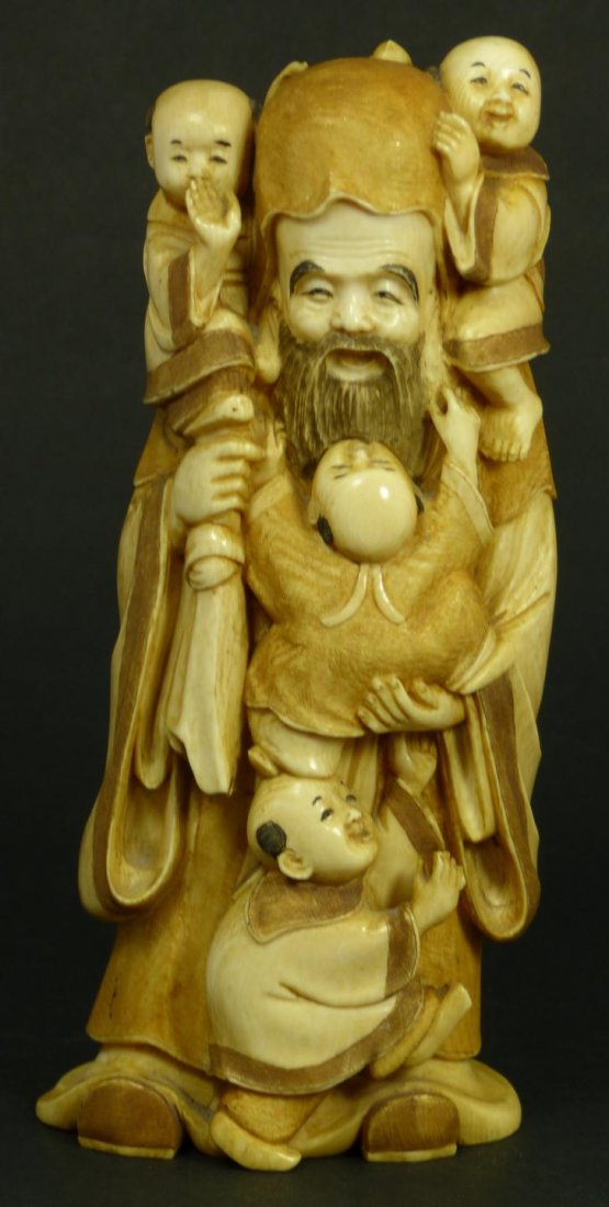 JAPANESE CARVED GROUP FIGURE OF MAN & CHILDREN: Old Japanese relief carved ivory figure depicting a wise man in hooded robe with four children climbing on him. Signed Dongshui to bottom. 19th/20th century. Measures 7 3/8" height (18.7cm). Total wei