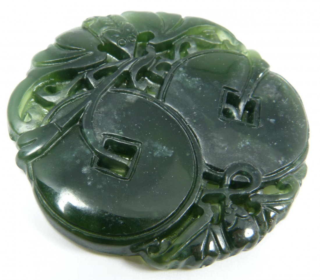 CHINESE RETICULATED SPINACH GREEN JADE: Chinese reticulated a spinach green jade circular plaque pendant depicting bats and coins. Translucent green jade. Measures approx. 2 1/8" diameters (5.3cm). Weight of 27 grams.