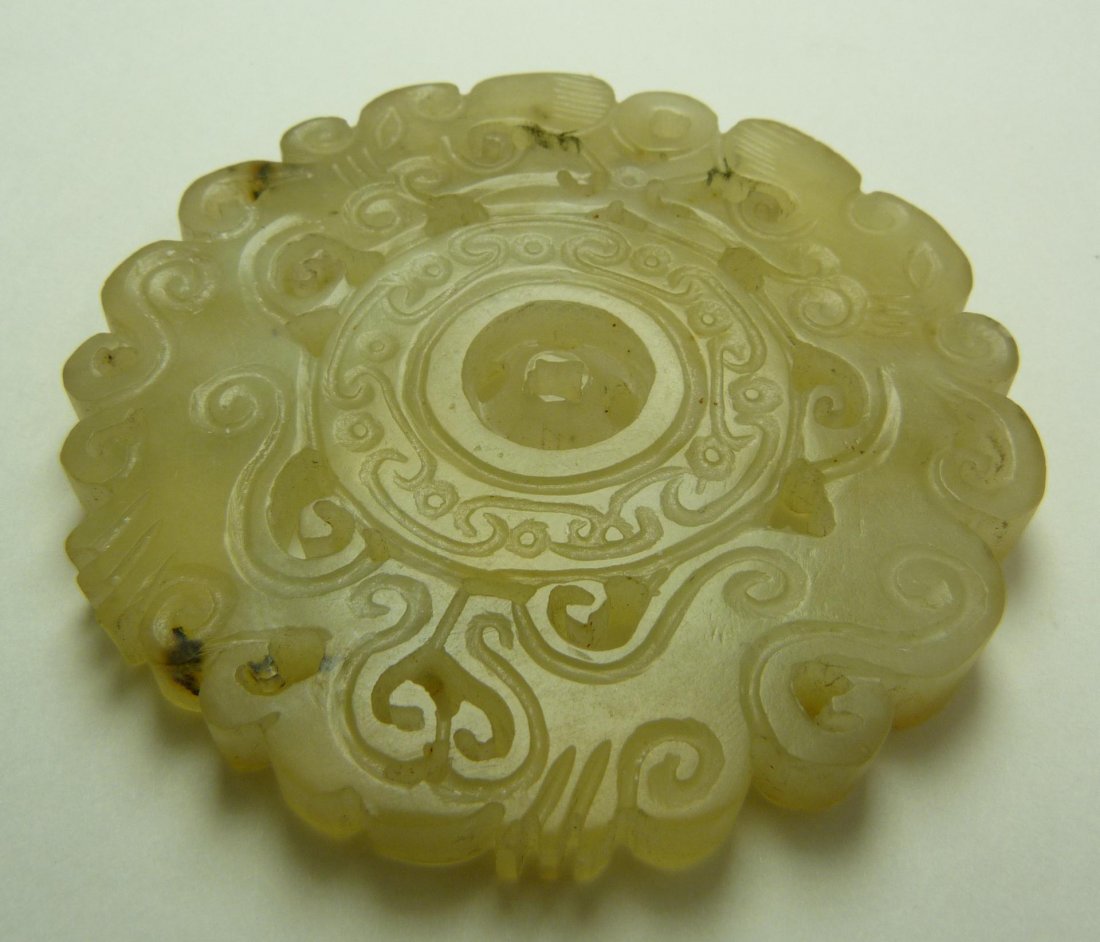 CHINESE QING FULLY RELIEF CARVED JADE DISC: Antique Chinese hand carved reticulated white jade Pi disc. Has archaic scrolled design depicting dragons with medallion to center. Beautiful translucent white jade with some mottling and russet pebbl