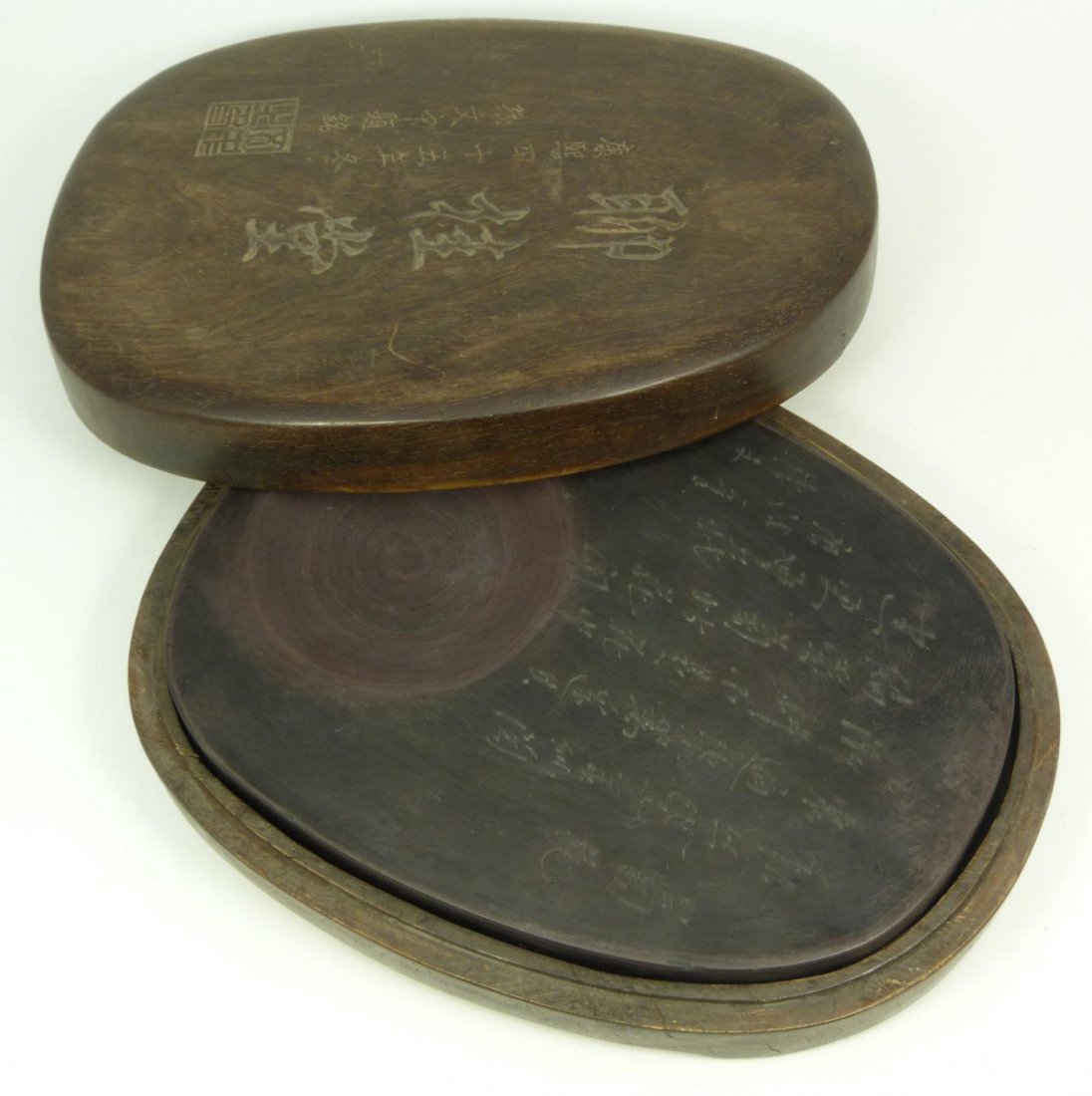 19th C CHINESE CARVED STONE INKWELL IN WOODEN BOX: Antique Chinese carved scholar's desk deep red inkstone having fitted wooden box. Has etched calligraphy stating Qianlong period and the artist Sun Wenzhong also states Liaoguitang / Chanhaoqisu / Cui