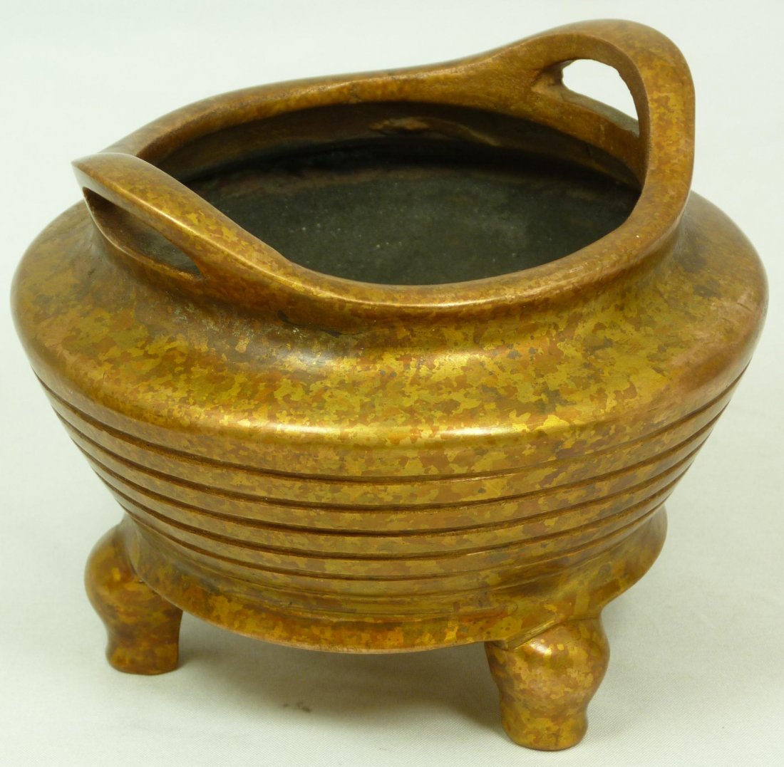 ANTIQUE CHINESE JUNOESQUE COPPER HANDLED CENSOR: Antique Chinese copper two handled tripod censor with relief parallel line design to exterior. Holds impressed four character marks to bottom. 18th/19th century. Measures 3 7/8" height x 5" diameter (