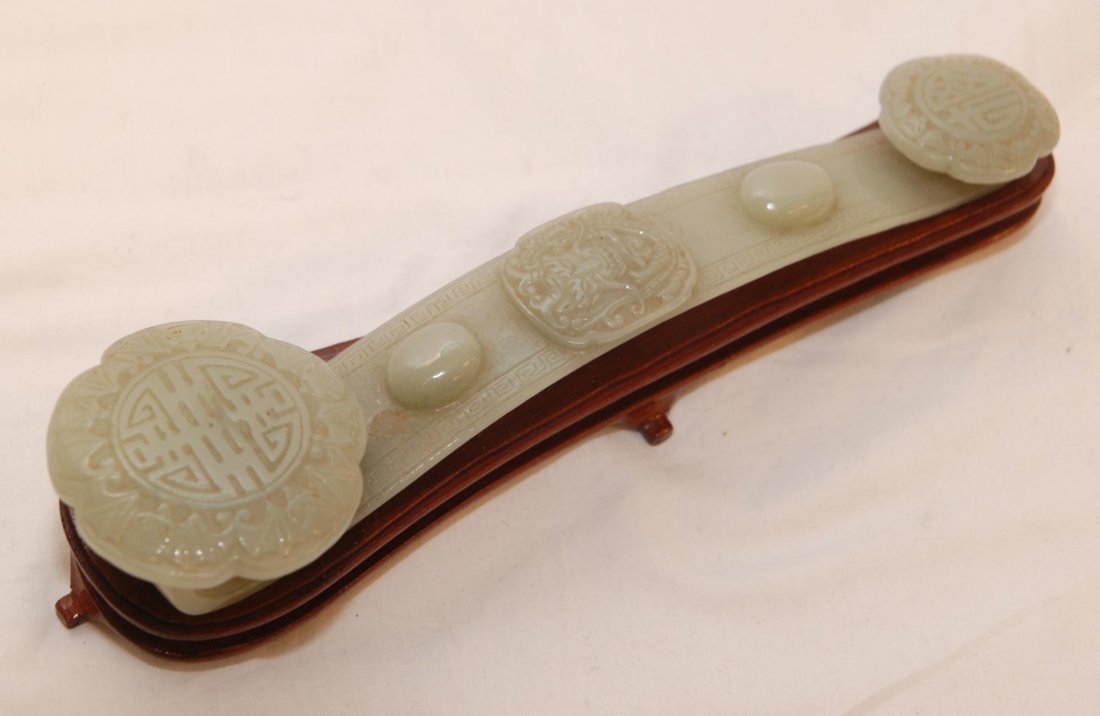 CHINESE CARVED JADE RUYI SCEPTER WITH STAND: Chinese relief carved ruyi scepter with three plaques depicting calligraphy symbols, dragons and bats. Has two oval studs to plank and etched Etruscan bordering. Translucent green and white jade color