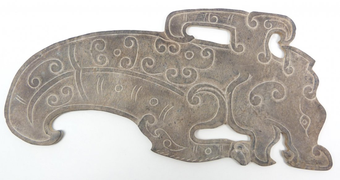 CHINESE WARRING STATES CARVED JADE DRAGONS BLADE: Antique Chinese warring states hand carved jade dragon plaque. Has a relief carved design throughout depicting archaic scroll designs with dragon head. Measures 9" length x 4 1/4" width (22.8cm x 10.7