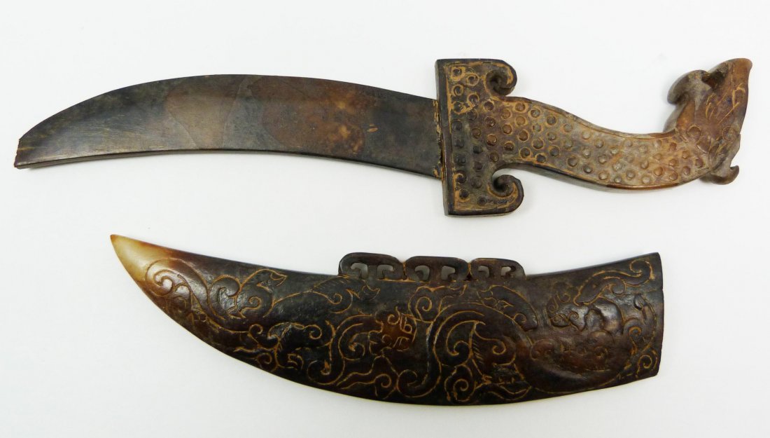 WARRING STATES CHINESE CARVED JADE DAGGER w SHEATH: Antique Chinese Warring States Era Chinese carved jade dagger with sheath. Figural Nian beast head with raised Nian design to sheath. Curved blade. Measures 9" length (22.8cm). Total weight of 123 gra