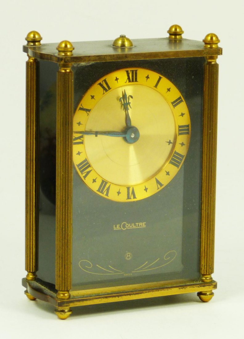 ANTIQUE LECOULTRE SWISS 8 DAY TRAVEL ALARM CLOCK: Antique Le Coultre 8 day travel alarm clock. Has black onyx front under glass screen. Gold face with metallic cobalt blue hour and minute hands. Has black enamel Roman Numerals. Black onyx side panels