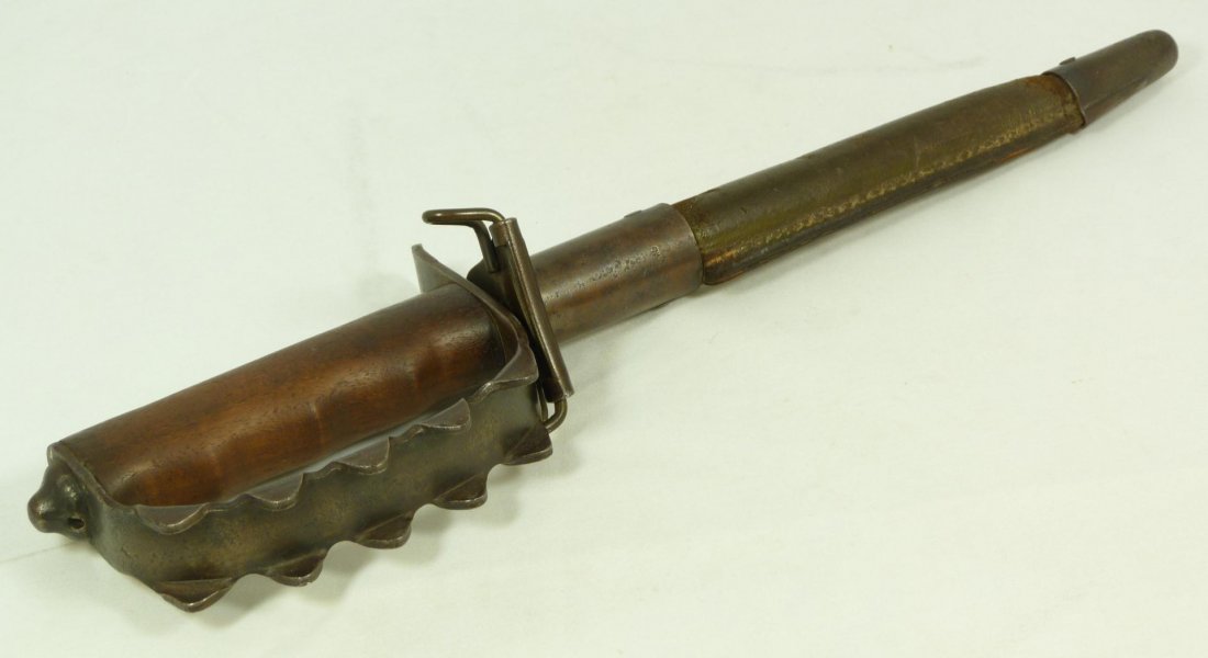 MODEL 1917 U. C. Co. AMERICAN TRENCH KNIFE: Model 1917 A. C. Co. American made World War I trench knife. Has triangular blade with 5 flanges to front of pommel. Has wooden handle. Created for close quarter combat. Includes original leather hilt