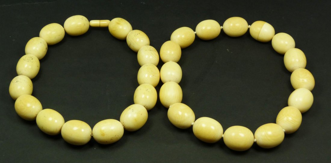 PAIR OF ANTIQUE CHINESE BEADED NECKLACES: Pair of antique Chinese ivory necklaces having egg shaped beads with screw clasps. Has a total of 30 beads, not including clasps, approx. 26mm x 19.5mm. Each necklace approx. 16" length (40.6cm). Tota