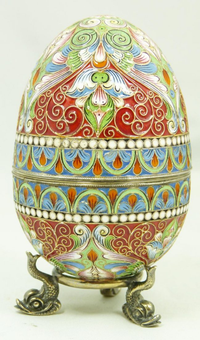 RUSSIAN SILVER ENAMELED EGG WITH STAND: Russian silver enameled egg box having elegant scrolled floral design. Gold wash interior. Includes stand with three figural fish feet. Piece holds Faberge marks. Holds 88 silver purity mark with Mosc