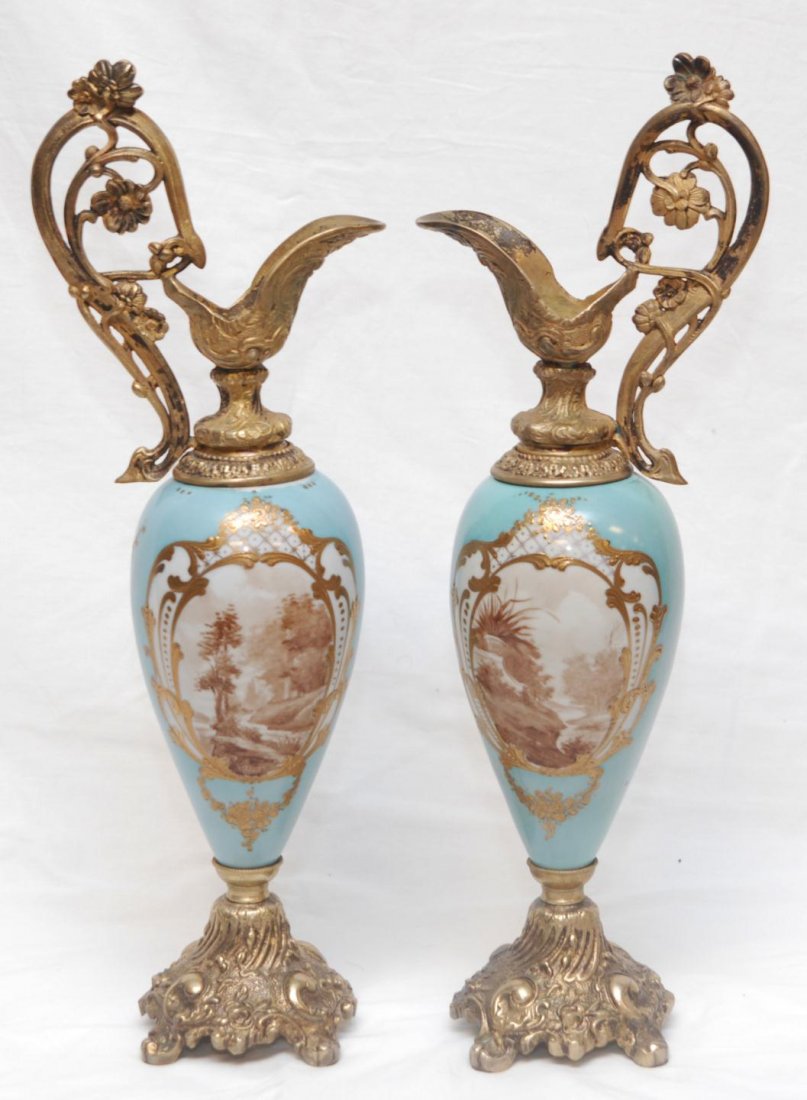 PAIR OF PORCELAIN & DORE BRONZE EWERS VAUT: Pair of antique hand painted French porcelain and gilded bronze ewers signed. Has landscape scenes with turquoise body. Gilded scroll, lattice and floral designs throughout. Each signed Vault. 2nd hal