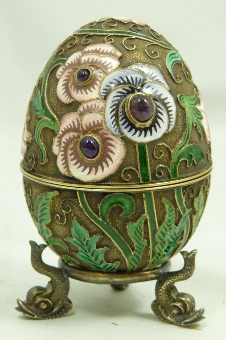 RUSSIAN SILVER ENAMELED JEWELED FLORAL EGG: Russian silver enameled egg box having multicolor floral design. 6 cabochon cut sapphire jewels mounted. Gold wash interior. Includes silver stand. Piece holds Cyrillic Ivan Petrovich Khlebnikov workm