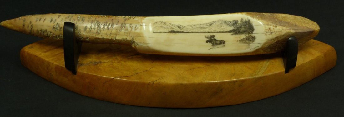 FOSSILIZED WALRUS TUSK SCRIMSHAW BY SOODALTER: Scrimshaw etching on fossilized walrus ivory tusk by Ron Soodalter (AMERICAN. 20th century) accomplished scrimshaw artist, historian, teacher and author. Depicts a male moose in a lake scene with fore