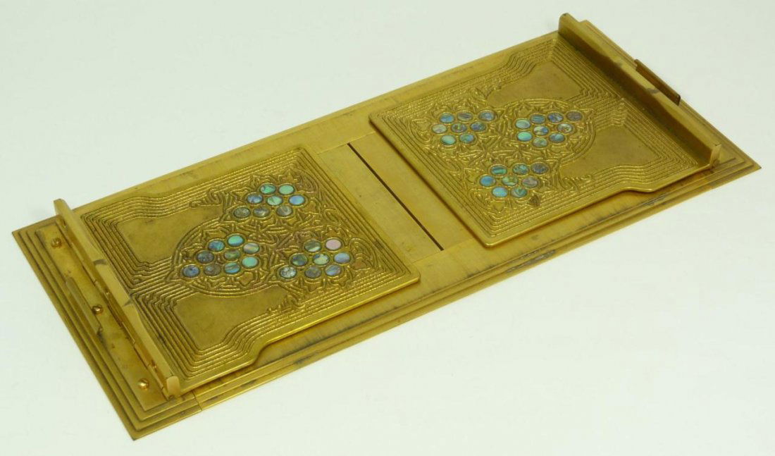 TIFFANY STUDIOS BRONZE BOOK RACK w ABALONE INLAY: Tiffany studios bronze book rack having round abalone disc inlay to each panel. Holds impressed 'TIFFANY STUDIOS NEW YORK II77' mark to bottom. Early 20th century. Measures 23 5/8" length at maximum x