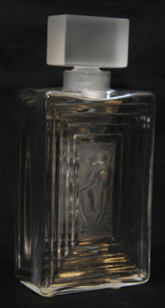 LALIQUE FRANCE CRYSTAL "DUNCAN" FLACON PERFUME B: Lalique French Crystal 'Duncan' Perfume Bottle Decanter depicting three nude females to front and back. Etched script Lalique France marks to bottom. Measures 7 7/8" height x 3 5/8" width x 2" depth (