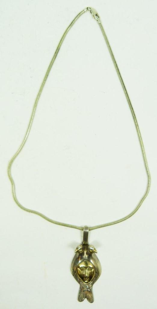 SERGIO BUSTAMANTE STERLING SILVER PENDANT NECKLACE: Pendant in the shape of a jester with bird shaped ears. Face is Gold over Sterling. Signed to base. Weighing 30.2 grams.