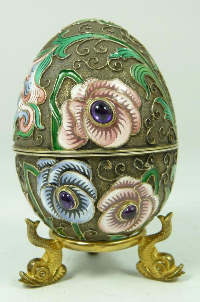 RUSSIAN SILVER ENAMELED JEWELED FLORAL EGG: Russian silver enameled egg box having multicolor floral design. 6 cabochon cut sapphire jewels mounted. Gold wash interior. Includes silver stand. Piece holds Cyrillic Ivan Petrovich Khlebnikov workm