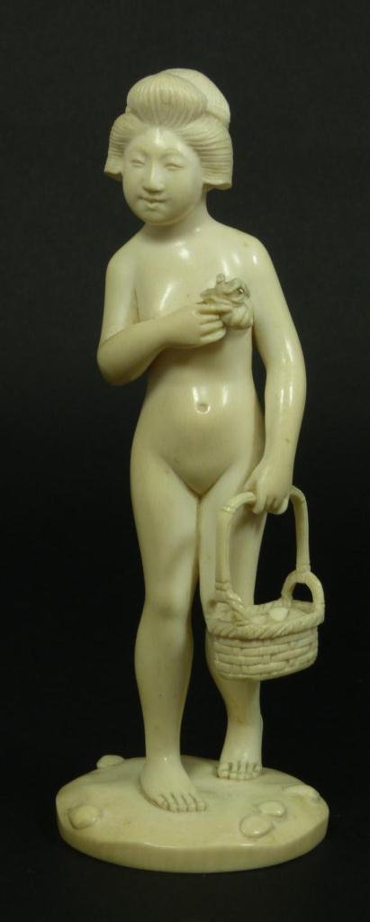JAPANESE CARVED IVORY NUDE GIRL FIGURE: An old Japanese hand carved ivory figure depicting a nude girl holding a basket of seashells. In her right hand is a shell with a crab in it. Holds etched calligraphy signature to bottom. 19th/20th ce