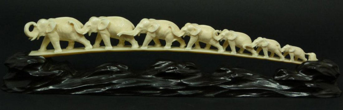 A CHINESE CARVED IVORY ELEPHANT BRIDGE w STAND: A Chinese fully relief carved ivory elephant bridge depicting graduating elephants with trunks up. Includes fitted earth from stand. 19th/20th century. Measures 2 1/4" height x 15" length + 1 5/8" bas