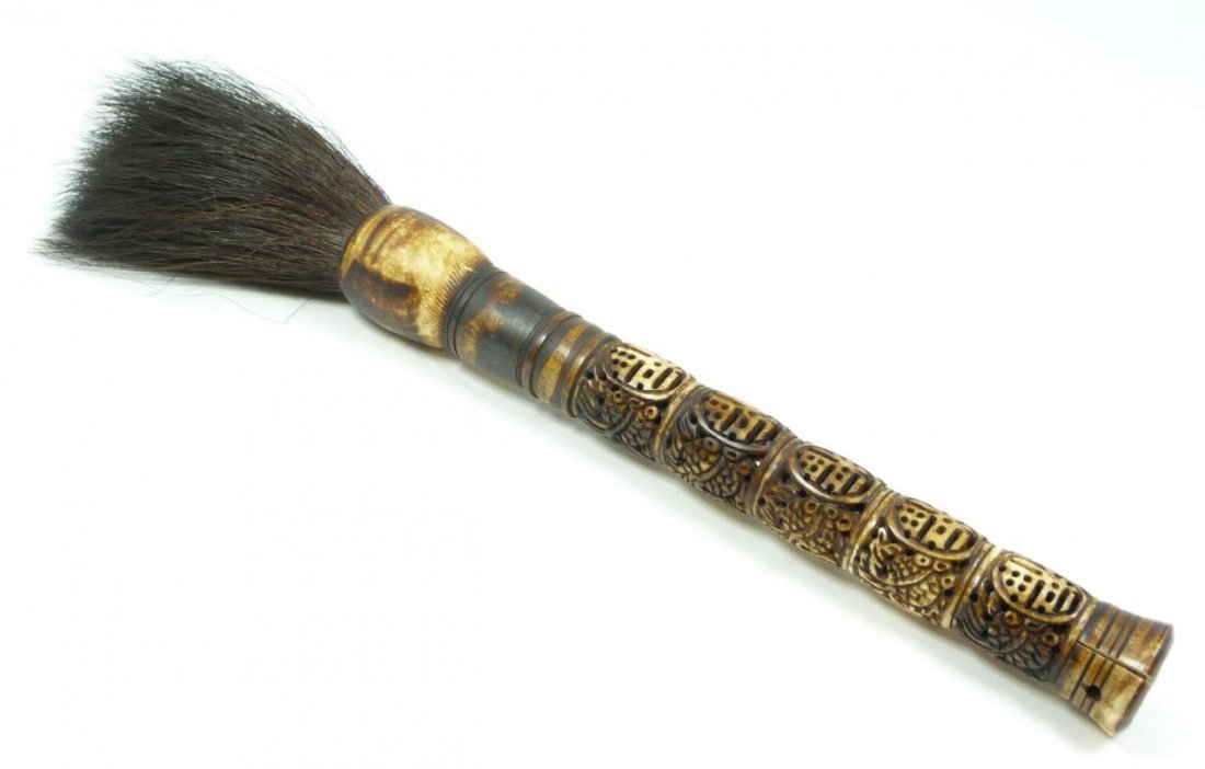 CHINESE CARVED OX BONE CALLIGRAPHY SCHOLAR'S BRUSH: A Chinese fully relief carved ox bone scholar's calligraphy brush. Depicts calligraphy and fish throughout handle. Hand measures 10 1/2" length (26.7cm). Total length of 15" (38.1cm). Total weight of 